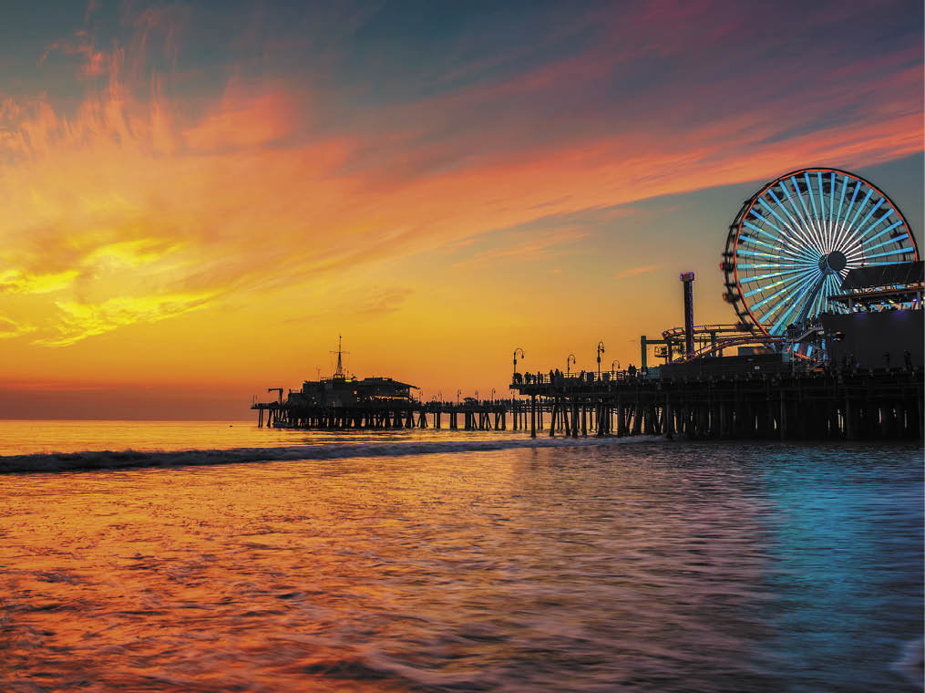 Visitors enjoy scenic sunset above Santa Monica Pier in Los Angeles, California 