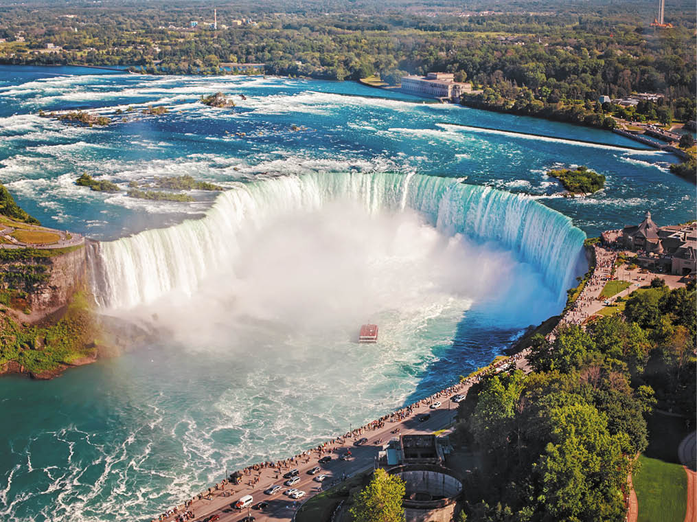 Aerial top landscape view of Niagara Falls and tour boat in water between US and Canada   Horseshoe of famous Canadian waterfall on sunny day