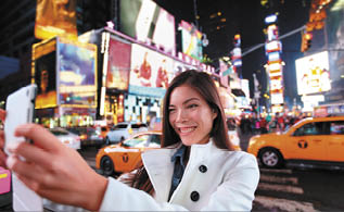 Happy woman tourist taking photo picture with tablet in New York City, Manhattan, Times Square  Girl traveler taking selfie joyful and happy smiling  Multiethnic Asian Caucasian woman in her 20s 